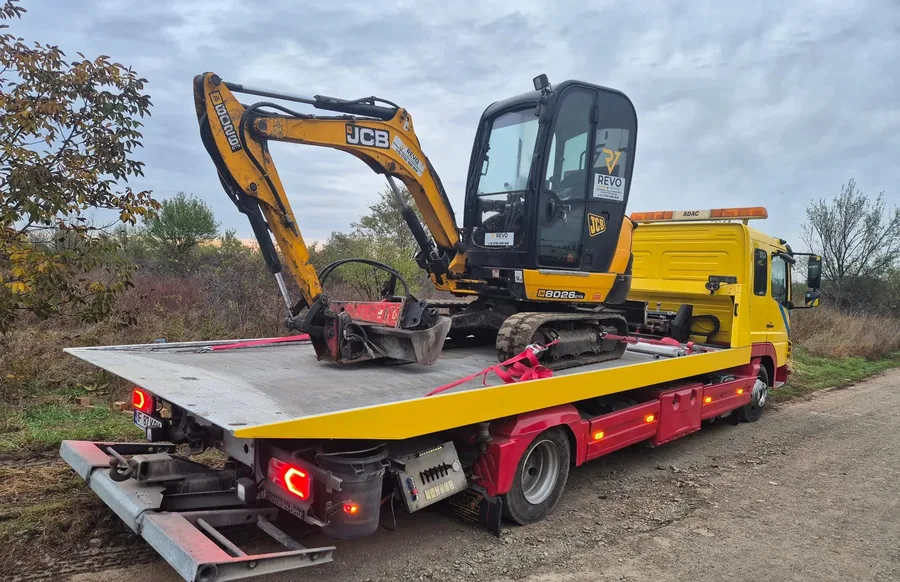 Excavator JCB încărcat pe platforma hidraulică